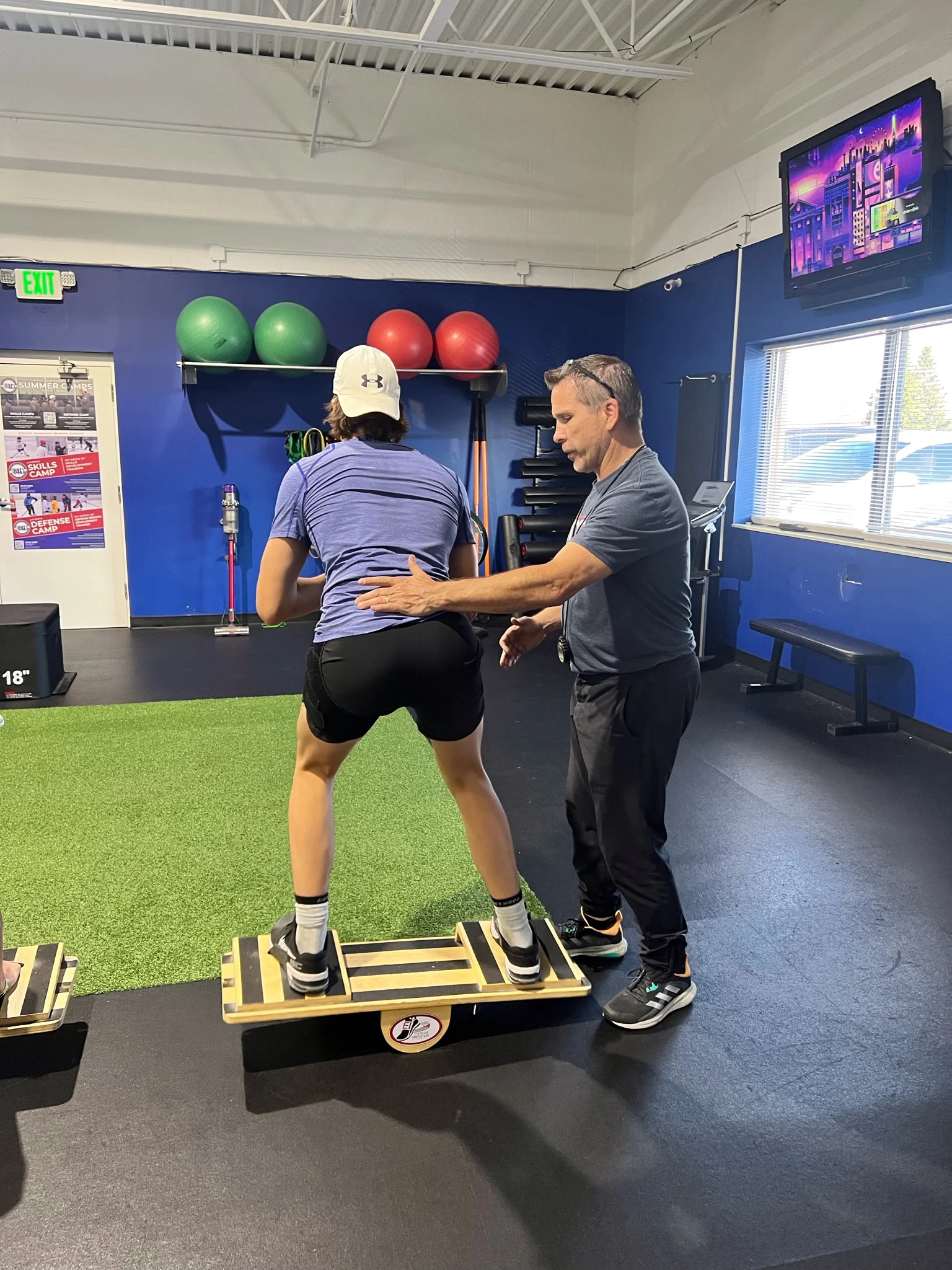 Exercise Innovation coach guiding an athlete through balance board training during a one-on-one sports performance session